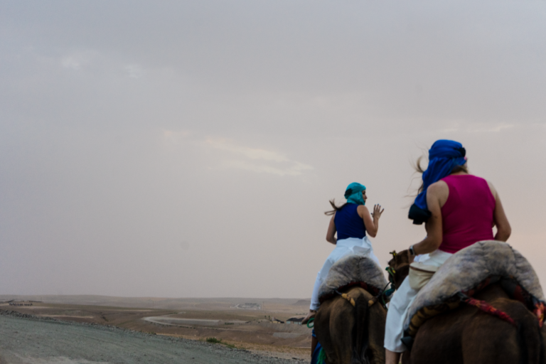Two travellers on a camel ride across the Agafay desert, photographed by a Morocco travel photographer